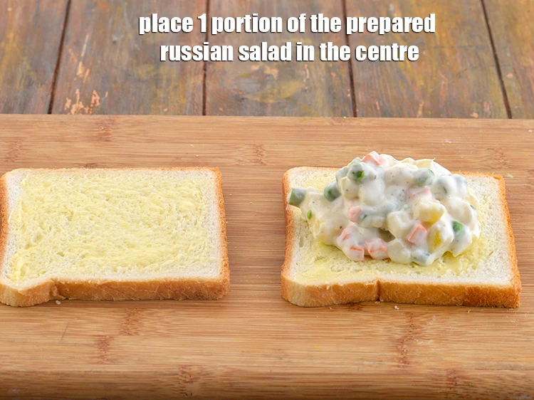 Step 13 – <p>Place 1 portion of the <strong>prepared russian salad</strong> in the centre of 1 buttered bread …
