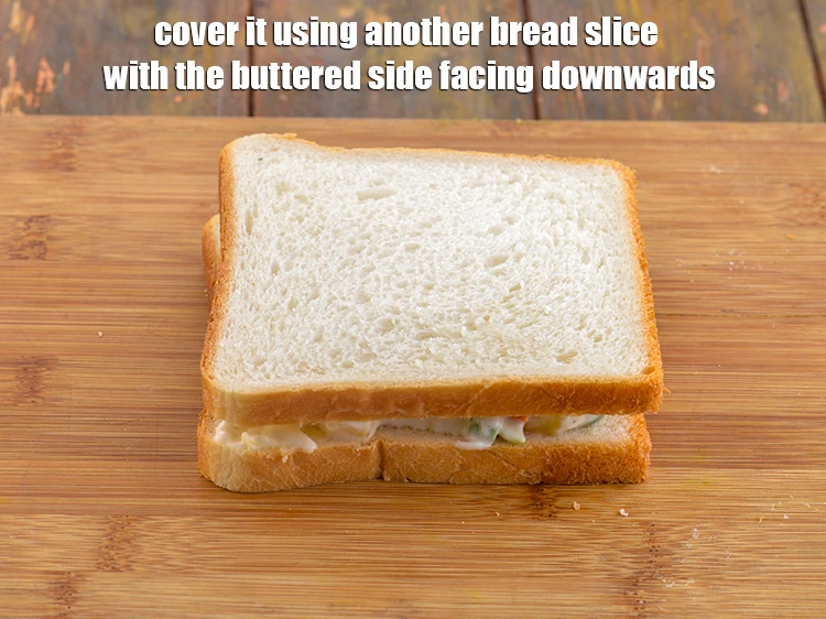 Step 15 – <p><strong>Cover</strong> <strong>it </strong>using another <strong>bread slice</strong> <strong>with the buttered</strong> side facing downwards.</p>