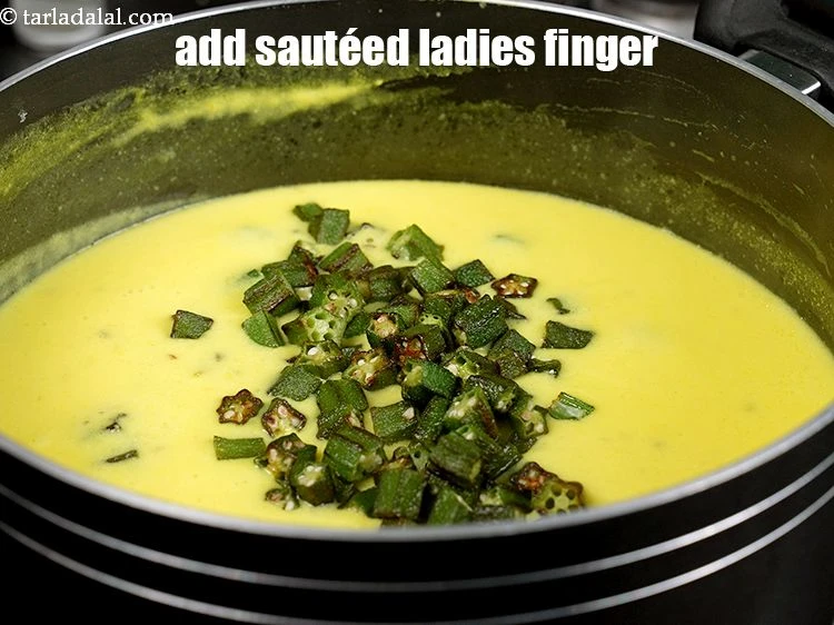 Step 24 – <p><strong>Just before serving</strong>, bring the kadhi to boil.&nbsp;Add the <strong>sauteed ladies finger</strong>.</p>