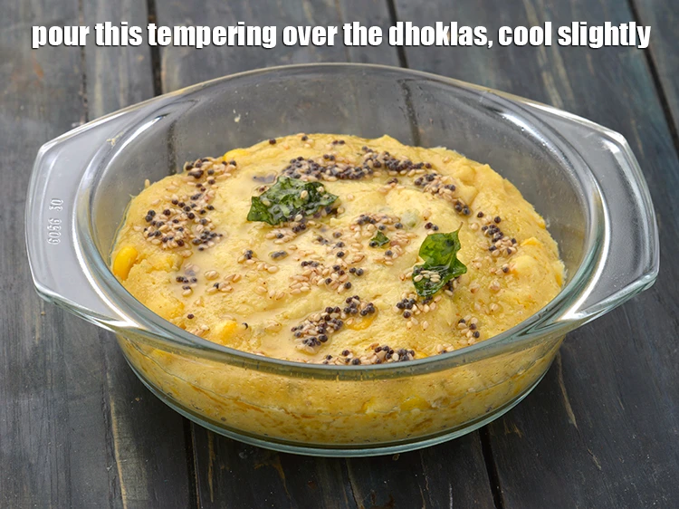 Step 15 – <p><span style="background-color:rgb(255,255,255);color:rgb(0,0,0);">Pour this tempering over the <strong>dhoklas</strong>, cool slightly.</span></p>