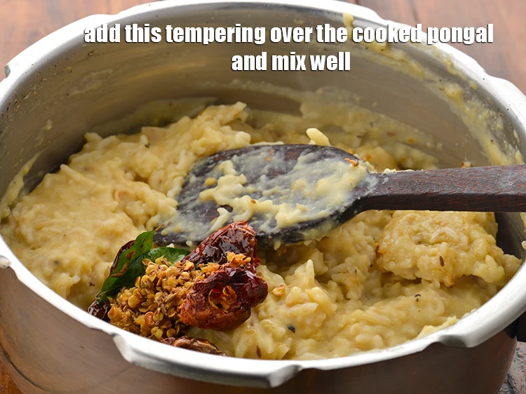 Step 11 – <p><span style="background-color:rgb(255,255,255);color:rgb(0,0,0);">Add this <strong>tempering</strong> over the <strong>cooked pongal </strong>and mix well.</span></p>