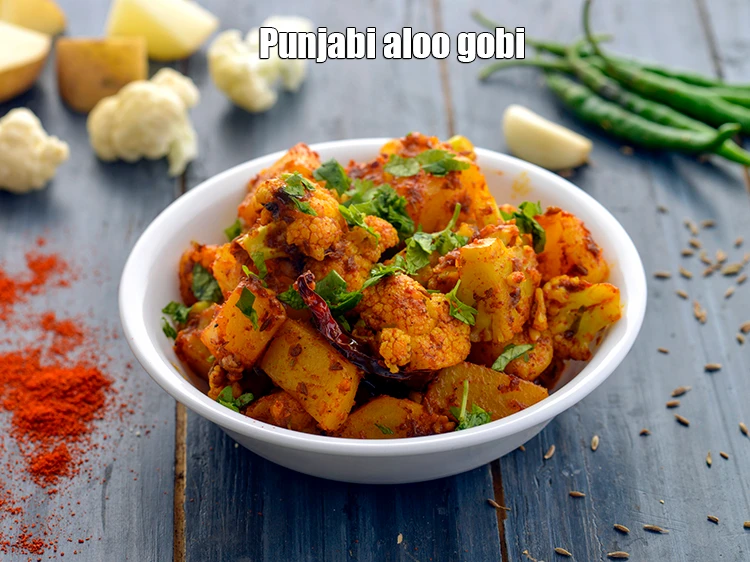 Step 23 – <p>Garnish the with a sprig of <a href="https://www.tarladalal.com/glossary-coriander-dhania-kothmir-369i"><u>coriander (dhania)</u></a> and serve &nbsp;<strong>aloo gobi dry recipe</strong><span …