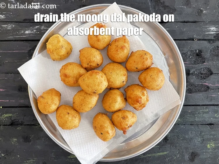 Step 23 – <html><head><meta charset="UTF-8"></head><body><p>Drain the&nbsp;<strong>Yellow Moong Dal Pakoda</strong>&nbsp;on an absorbent paper.&nbsp;<br>&nbsp;</p></body></html>