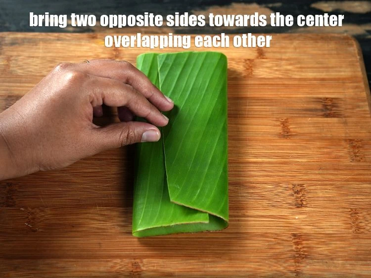 Step 18 – <p>Bring two opposite sides of the banana leaf towards the center overlapping each other.</p>