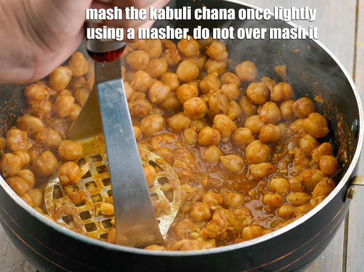 Step 29 – <p><strong>Mash </strong>the <strong>kabuli chana</strong> once lightly using a masher, do not over mash it. This …