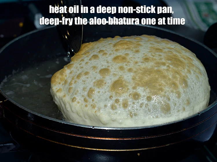 Step 40 – <p>Heat the <a href="https://www.tarladalal.com/glossary-oil-671i"><u>oil </u></a>in a deep non-stick pan, deep-fry the <strong>aloo bhatura</strong> one at …