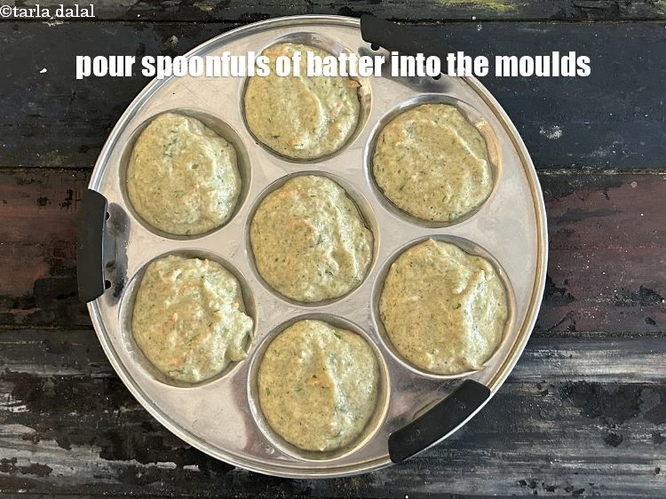 Step 30 – <p>Pour spoonfuls of the batter into greased idli moulds.</p>