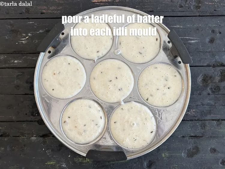 Step 30 – <p>Pour a ladleful of batter into each greased idli mould.</p>
