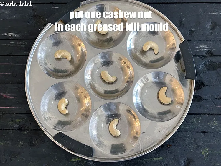 Step 37 – <p>Put one cashew nut in each idli mould.</p>