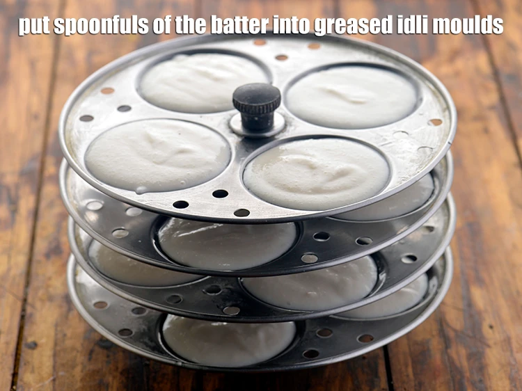 Step 26 – <p>Put spoonfuls of the batter into greased idli moulds. Do not overfill as the idlis …