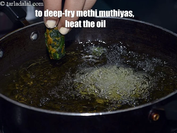 Step 20 – <p>To deep-fry methi muthiyas, heat the <a href="https://www.tarladalal.com/glossary-oil-671i"><u>oil</u></a> in a kadhai and drop a few …