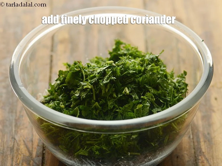 Step 24 – <p>Add 1/2 cup finely <a href="https://www.tarladalal.com/glossary-coriander-dhania-kothmir-369i#ing_2365"><u>chopped coriander (dhania)</u></a><u>.</u></p>