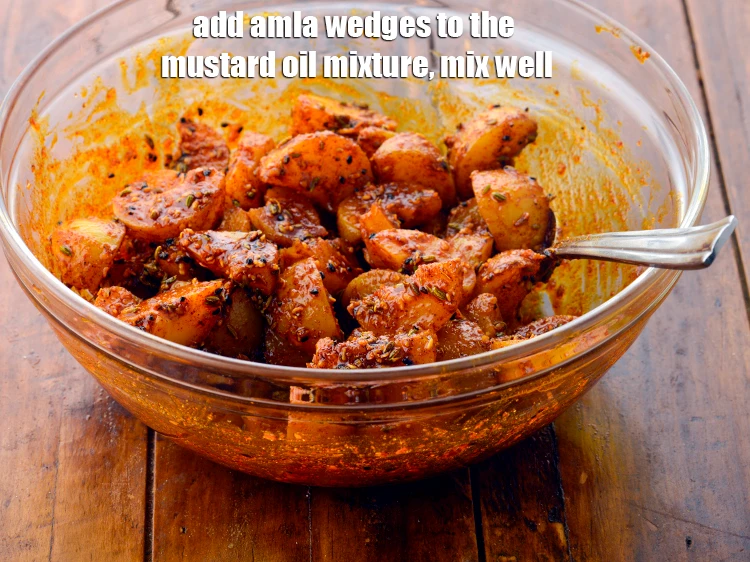 Step 10 – <p><span style="background-color:rgb(255,255,255);color:rgb(0,0,0);">Add the <strong>amla wedges</strong> to the mustard oil mixture, mix well and keep aside …