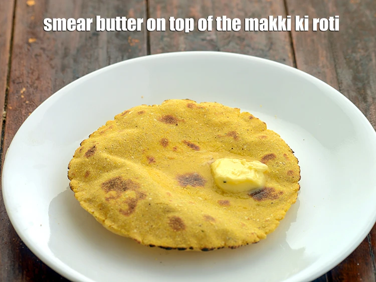 Step 13 – <p>Remove the in a plate. Smear <a href="https://www.tarladalal.com/how-to-make-homemade-white-butter-safed-makhan-recipe-42484r">homemade white butter </a>on top of&nbsp;<strong>makki ki roti.</strong></p>