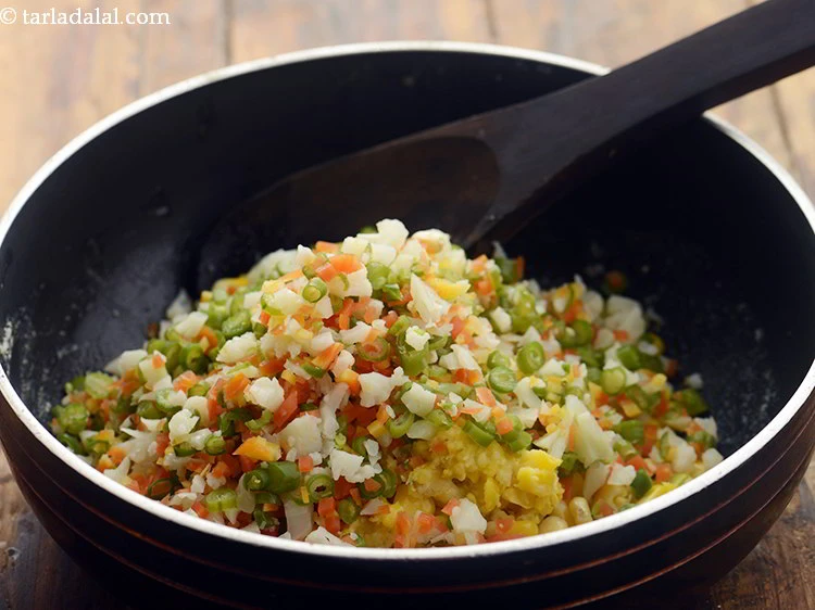 Step 11 – <p>Add 1 cup finely <a href="https://www.tarladalal.com/glossary-mixed-vegetables-mixed-sabzi-723i#ing_2543"><u>chopped and boiled mixed vegetables</u></a>. We have used cauliflower, french …