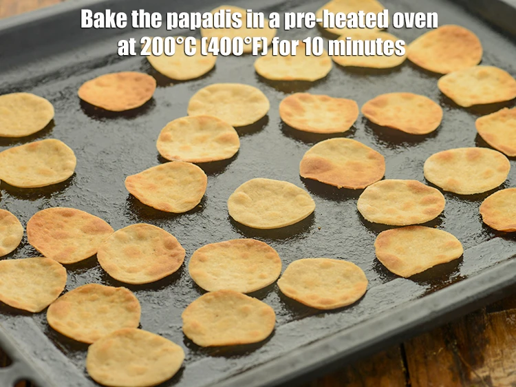 Step 15 – <p>Bake the <strong>papadis</strong> in a pre-heated oven at 200°C (400°F) for 10 minutes, turning them …