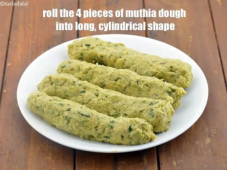 Step 23 – <p>Roll the 4 pieces of muthia dough into long,&nbsp;cylindrical shape.</p>
