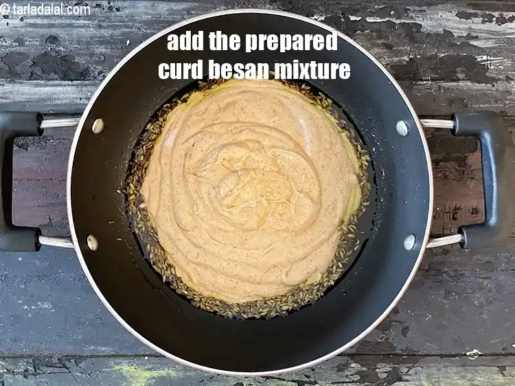 Step 27 – <p>When the seeds crackle, add the curds-besan mixture.</p>