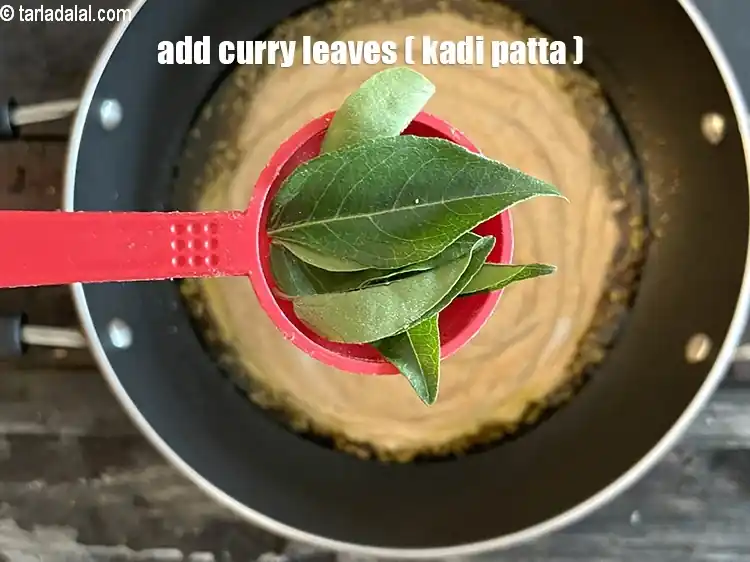 Step 28 – <html><head></head><body><p>Add&nbsp;5-6&nbsp;<a href="glossary-curry-leaves-kadi-patta-kadipatta-388i">curry leaves (kadi patta)</a>.</p></body></html>