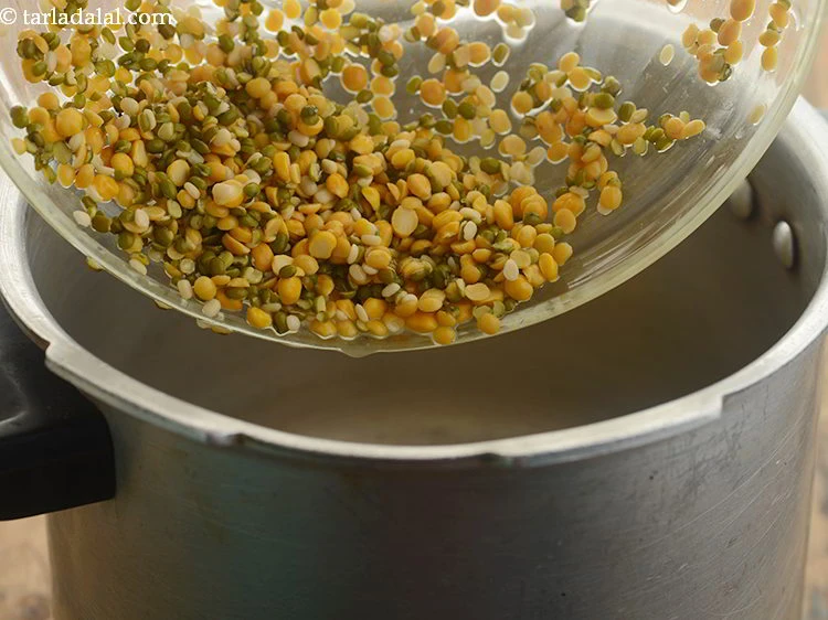 Step 29 – <p>Transfer the dals in a pressure cooker.</p>
