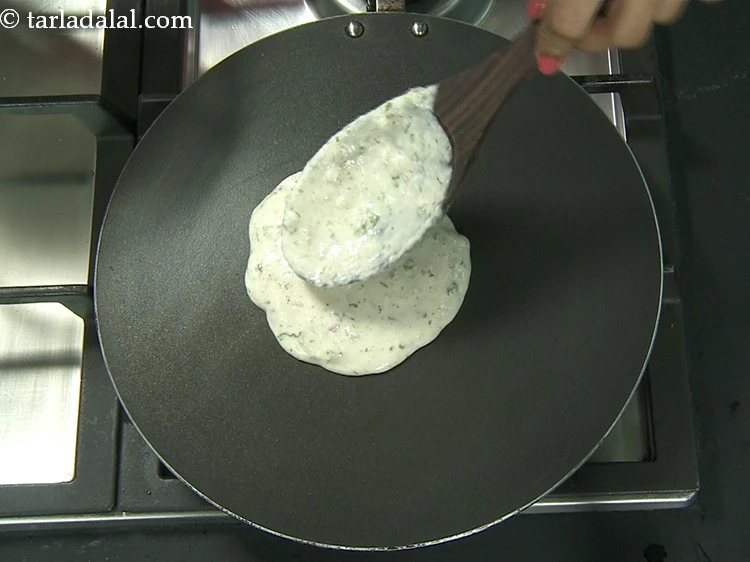 Step 18 – <p>Pour a ladleful of oats onion dosa batter on the tava (griddle).</p>