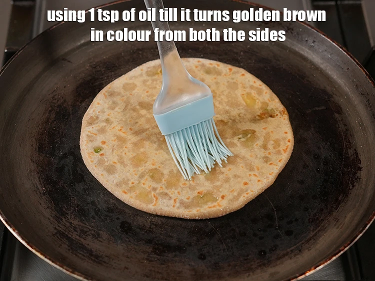 Step 18 – <p><span style="background-color:rgb(255,255,255);color:rgb(0,0,0);">Cook the <strong>paratha</strong> using 1 tsp of </span><a href="https://www.tarladalal.com/glossary-oil-671i"><u>oil&nbsp;</u></a><span style="background-color:rgb(255,255,255);color:rgb(0,0,0);"> till it turns golden …