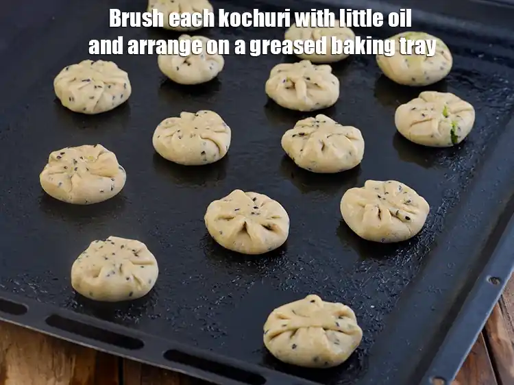 Step 11 – <p>Brush each <strong>kochuri</strong> with little <a href="https://www.tarladalal.com/glossary-oil-671i"><u>oil</u></a> and arrange on a greased baking tray.</p>