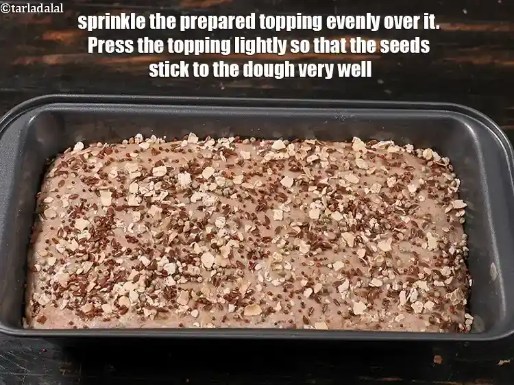 Step 30 – <p>Sprinkle the prepared topping evenly over it.&nbsp;Press the topping lightly so that the seeds stick …