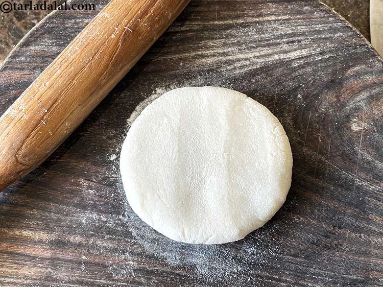 Step 11 – <p>કણકનો એક ભાગ લો અને તેને તમારા બંને હથેળીઓ વચ્ચે થપથપાવીને સપાટ કરો. તે આ …