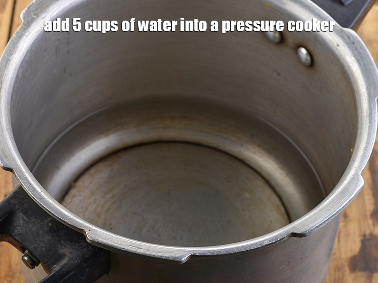 Step 2 – <p>પ્રેશર કુકરમાં ૫ કપ પાણી ઉમેરો.</p>