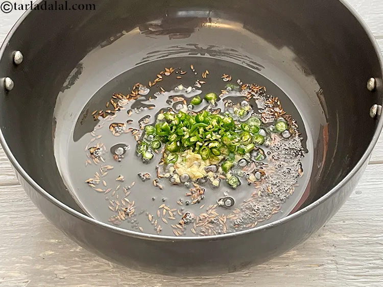 Step 6 – <p style="margin-left:0px;">2 ટેબલસ્પૂન <a href="/glossary-green-chillies-hari-mirch-gujarati-331i#ing_2388"><u>સમારેલા લીલા મરચાં (chopped green chillies)</u></a> ઉમેરો.</p>