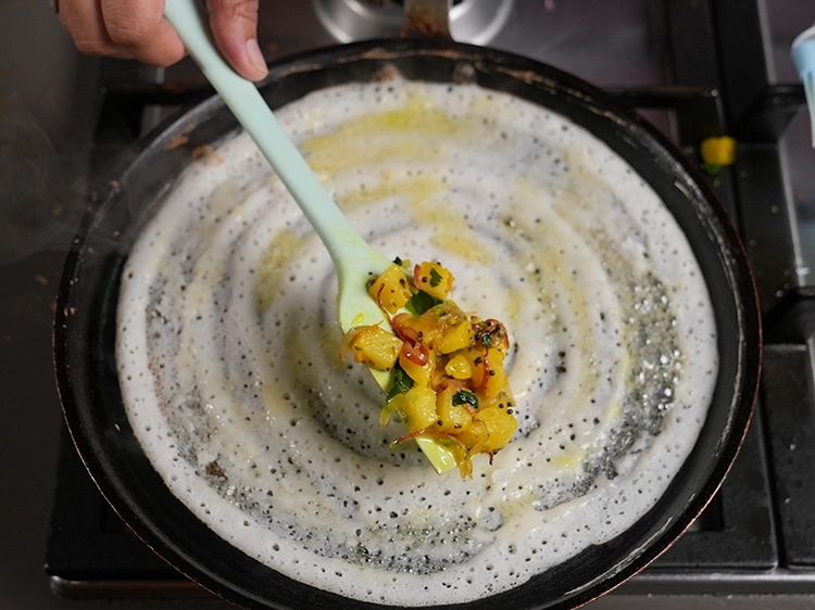 Step 25 – <p style="margin-left:0.0px;">તૈયાર કરેલા આલુ મસાલાનો ૧/૪ ભાગ ઢોસા પર સરખી રીતે ફેલાવો અને ઢોસા ગોલ્ડન …