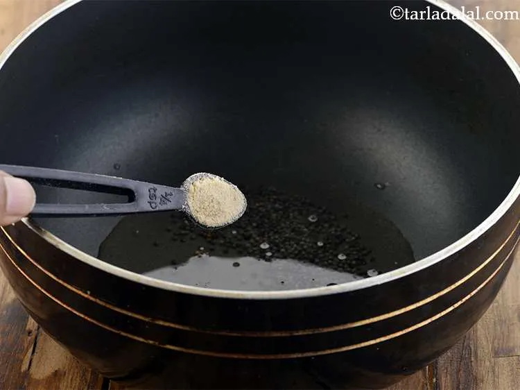 Step 2 – <p>જ્યારે દાણા તતડવા માંડે, ત્યારે તેમાં હીંગ મેળવી મધ્યમ તાપ પર થોડી સેકંડ સુધી સાંતળી …