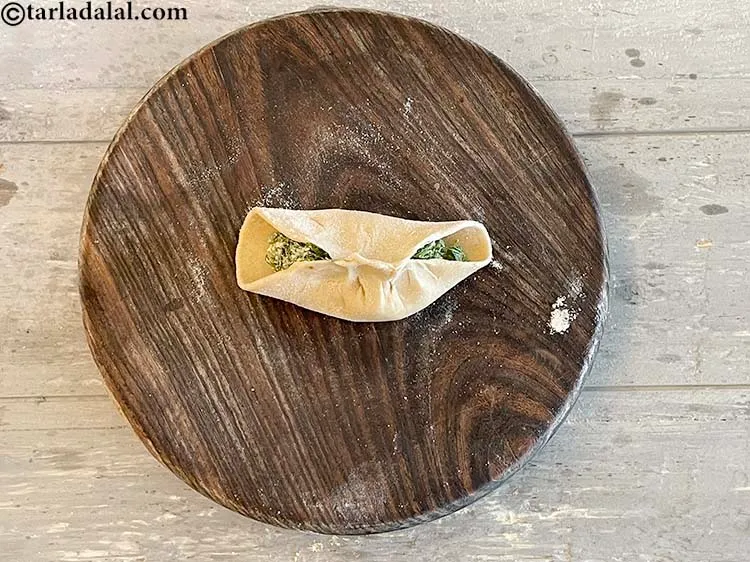 Step 20 – <p>રોટલીની બંને બાજુઓ વચ્ચે વાળો અને સારી રીતે સીલ કરો જેથી સ્ટફિંગ બહાર ન ઢોળાય.</p>