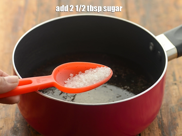 Step 4 – <p>ખાંડ ઉમેરો. ખાંડને પાઉડર ગોળ સાથે બદલી શકાય છે. તમારા ઈલાયચી ચાના કપનો સ્વાદ વધારવા …