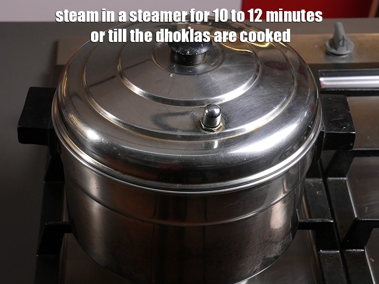 Step 37 – <p>સ્ટીમરમાં ૧૦ થી ૧૨ મિનિટ સુધી અથવા ઢોકળા રાંધાય ત્યાં સુધી બાફવા દો.</p>