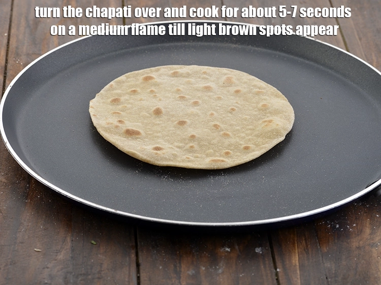 Step 14 – <p>રોટલી પલટાવીને મધ્યમ તાપ પર લગભગ ૫-૭ સેકન્ડ સુધી હળવા ભૂરા રંગના ડાઘ દેખાય ત્યાં …