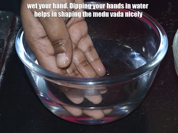 Step 21 – <p>તમારા હાથ ભીના કરો. તમારા હાથ પાણીમાં બોળવાથી <strong>મેદુ વડા</strong>ને સારી રીતે આકાર આપવામાં મદદ …