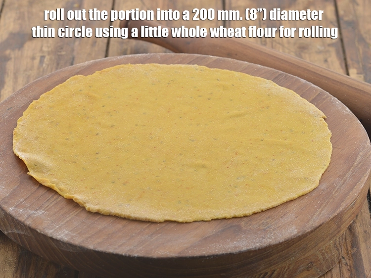 Step 13 – <p>ભાગને ૨૦૦ મીમીના આકારમાં રોલ કરો. (૮”) વ્યાસનો પાતળો ગોળો, થોડો ઘઉંનો લોટ વાટીને ગોળ …