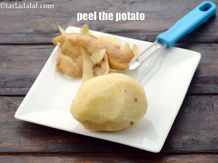Step 2 – <p>બટાકાને પીલરનો ઉપયોગ કરીને છોલી લો.</p>