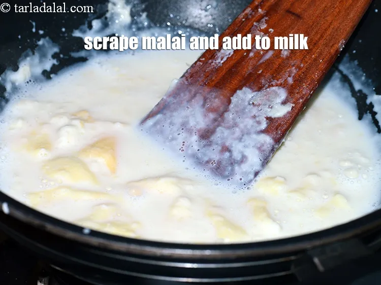 Step 7 – <p>મલાઈને <span style="background-color:rgb(255,255,255);color:rgb(0,0,0);">સ્ક્રેપ</span> <span style="background-color:rgb(255,255,255);color:rgb(0,0,0);">કરતા રહો</span> અને તેને દૂધમાં ઉમેરો.</p>