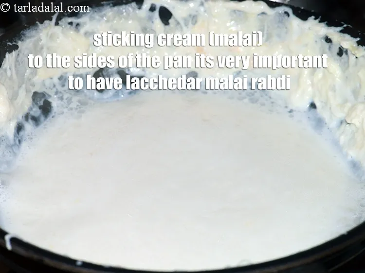 Step 11 – <p><span style="background-color:rgb(255,255,255);color:rgb(0,0,0);">તવાની બાજુઓમાં ક્રીમ (મલાઈ) ચોંટાડવાથી લચ્છેદાર મલાઈ રબડી હોવી ખૂબ જ મહત્વપૂર્ણ છે.&nbsp;</span></p>