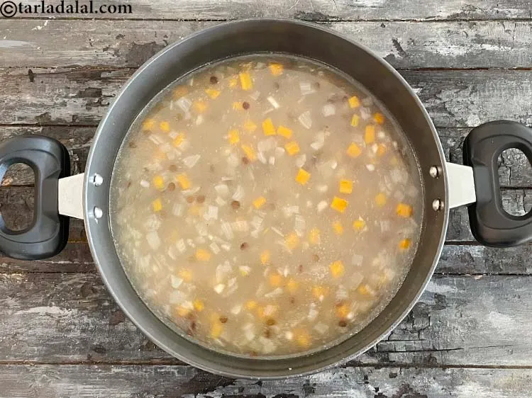 Step 22 – <p>જવ-મસૂરના મિશ્રણને ઊંડા નોન-સ્ટીક પેનમાં નાખો. ફ્લેમ ચાલુ કરો.</p>