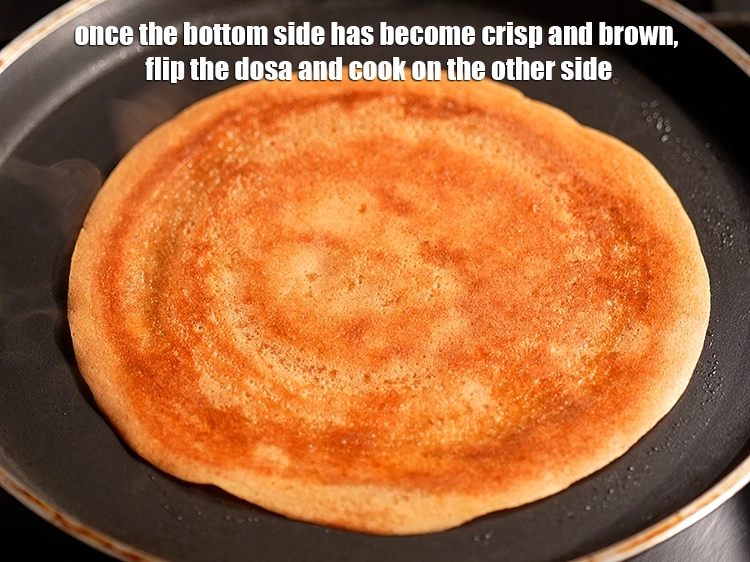 Step 14 – <p>એકવાર નીચેની બાજુ કરકરી અને ભૂરા થઈ જાય, પછી ઢોસાને પલટાવીને બીજી બાજુ રાંધો.</p>