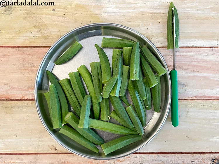 Step 4 – <p>કાળજીપૂર્વક લંબાઈની દિશામાં ચીરો, જેથી ભાગો અલગ ન થાય. છરી દ્વારા ભીંડા કાપતી છબી જુઓ.</p>