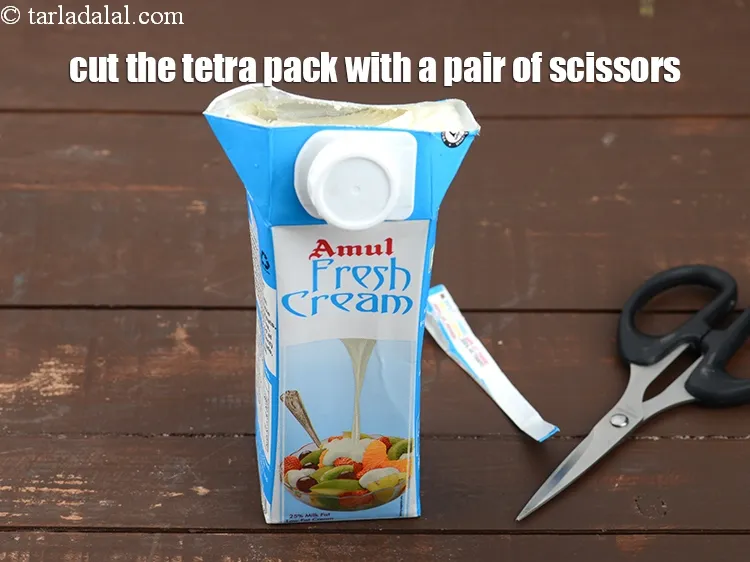 Step 4 – <p>ફ્રીઝરમાંથી ફ્રેશ ક્રીમ કાઢો અને ટેટ્રા પેકને કાતર વડે કાપી નાખો.</p>