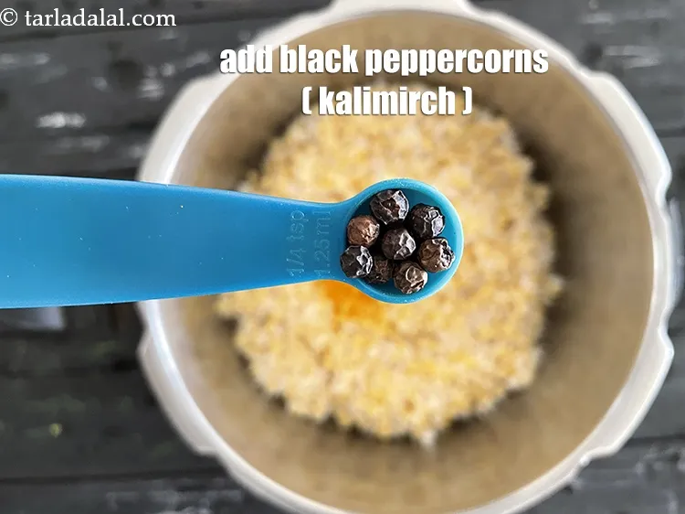 Step 9 – <p><a href="https://www.tarladalal.com/glossary-black-peppercorns-kali-mirch-kalimirch-gujarati-566i"><u>કાળી મરી (black peppercorns (kalimirch)</u></a> ઉમેરો. પીળી મગની દાળની ખીચડીને વધુ સ્વાદિષ્ટ અને સુગંધિત …