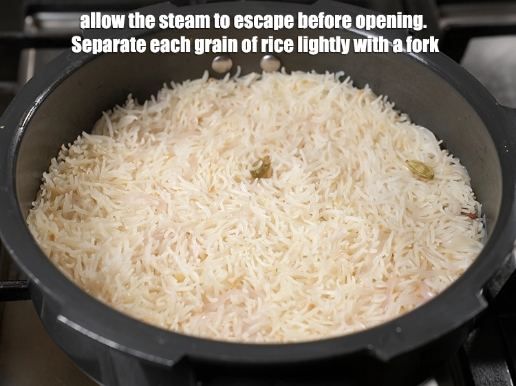 Step 15 – <p>ખોલતા પહેલા વરાળ બહાર નીકળવા દો. ચોખાના દરેક દાણાને કાંટો વડે હળવા હાથે અલગ કરો.</p>