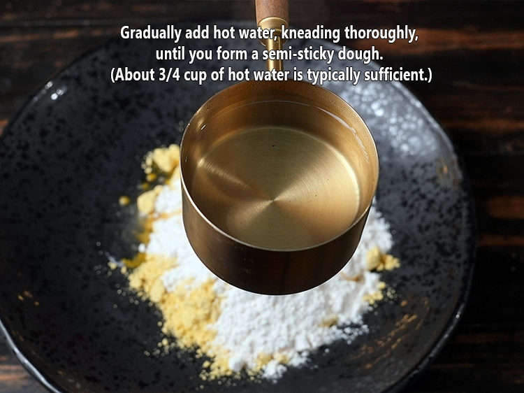 Step 5 – <p>ધીમે ધીમે ગરમ પાણી ઉમેરો, સારી રીતે ભેળવો, જ્યાં સુધી તમે અર્ધ-ચીકણું કણક ન બનાવો. …