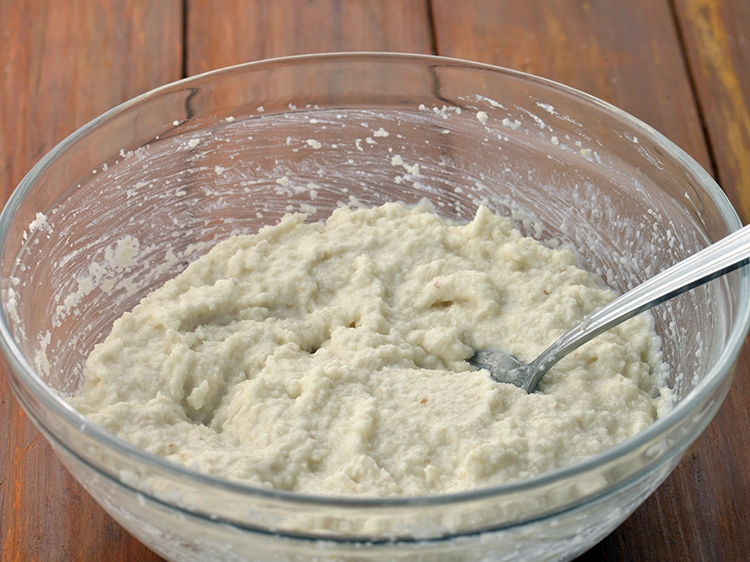 Step 4 – <p>લગભગ ½ કપ પાણી ઉમેરો, ચમચીની મદદથી સારી રીતે મિક્સ કરીને બેટર બનાવો.</p>